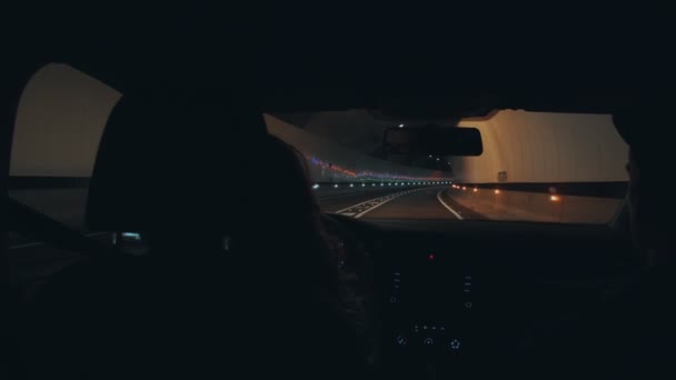 Pareja conduce coche a través de túnel oscuro de montaña — Vídeo de stock