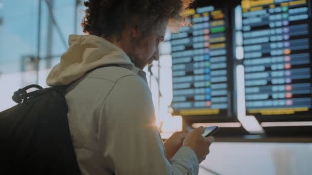 Männlicher Millennial-Reisender in der Nähe des Flughafen-Infoscreens — Stockvideo