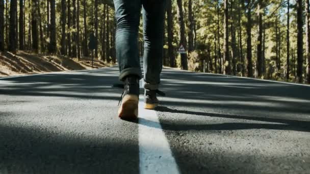 Закрывая обувь, пешеходы идут посреди дороги — стоковое видео