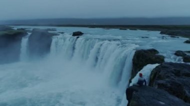 Şafak vakti epik İzlanda Godafoss Şelalesi 'nde yalnız adam