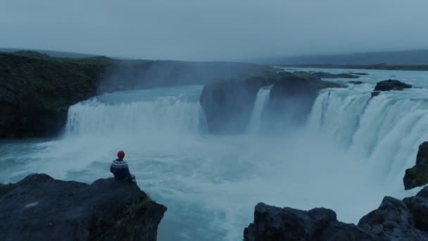 Hombre solitario en la épica cascada islandesa Godafoss al atardecer — Vídeos de Stock