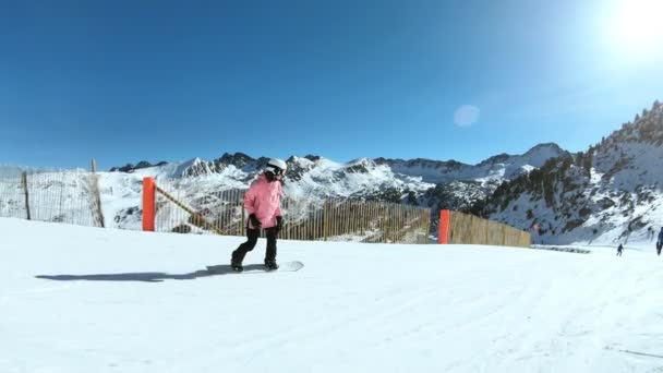 Unga hipster kvinnlig snowboardåkare på solig sluttning — Stockvideo