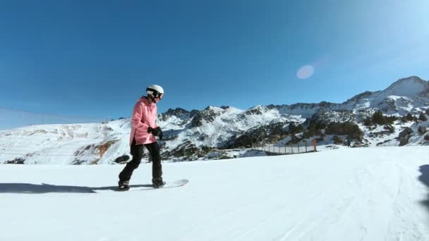 Jeune hipster femme snowboarder sur pente ensoleillée — Video