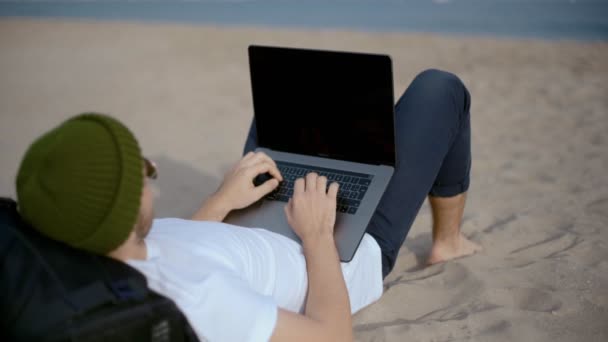 Millennial Nomad fungerar på laptop på stranden — Stockvideo