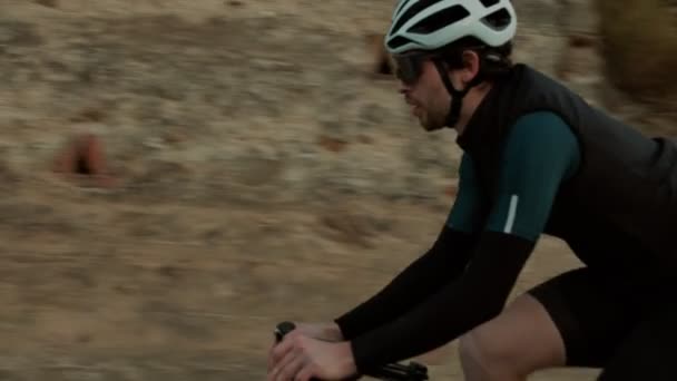 Rennradfahrer bei Sonnenuntergang auf Bergstraße unterwegs — Stockvideo