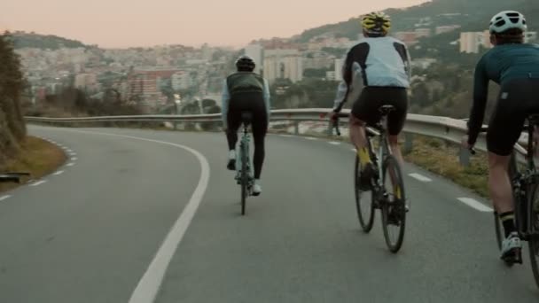 Út kerékpárosok lovaglás a naplemente hegyi úton — Stock videók