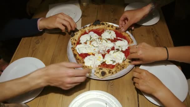 Groep vrienden delen pizza in restaurant — Stockvideo