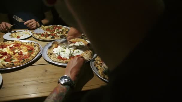 Grupo de amigos comparten pizza en el restaurante — Vídeo de stock