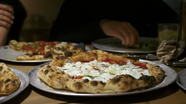 Группа друзей делится пиццей в ресторане — стоковое видео