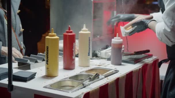 Food truck vendor serves hot dogs at night — Stock Video