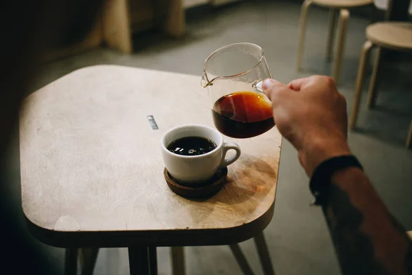 Specialty coffee lover pours filter into cup