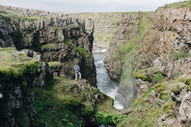 Erkekler nehir vadide uçurumun kenarında durur