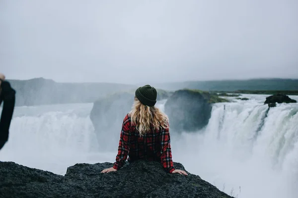 Bastante jovem fêmea senta-se na beira do penhasco iceland — Fotografia de Stock