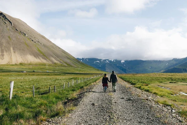 Casal caminha para longe na estrada rural — Fotografia de Stock