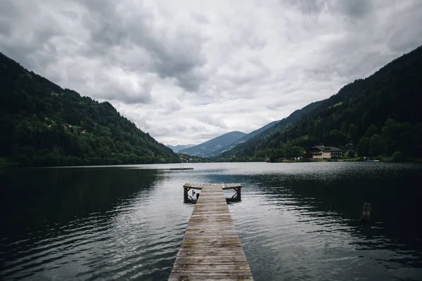 Wooden pier goes into pristine alpine lake — Stock Photo, Image