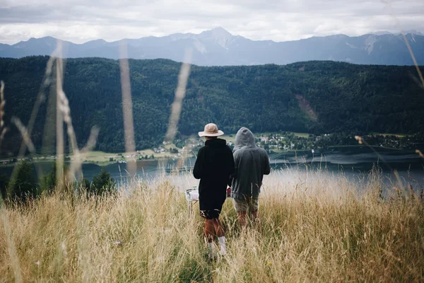 Dos hombres en la cima de la montaña disfrutan de la vista —  Fotos de Stock