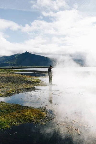 人站在盖瑟湖旁边,蒸汽在冰原 — 图库照片
