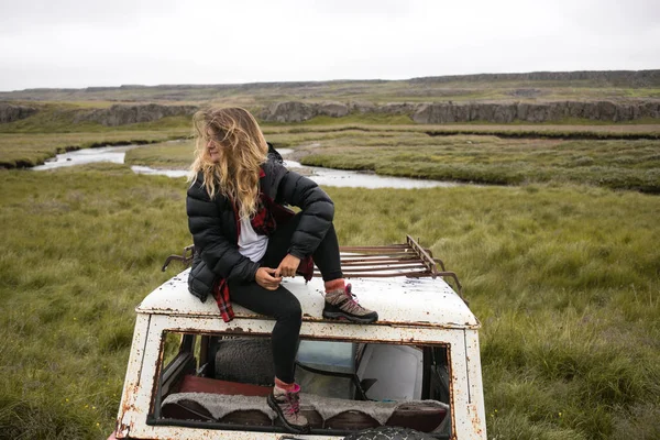 Jovem milenar na moda no velho ferro-velho carro jarda — Fotografia de Stock