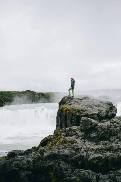 Abenteuerlustiger Mann steht am Rande des Klippenwasserfalls — Stockfoto