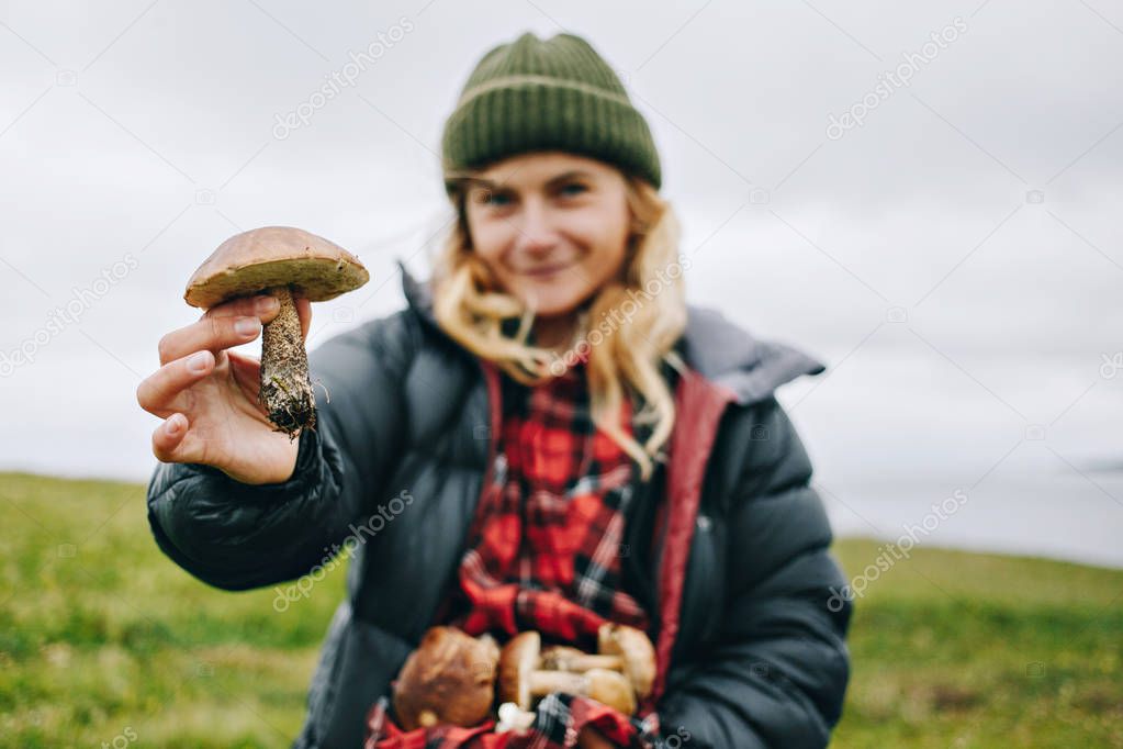 Young woman nature lover holds wild mushrooms