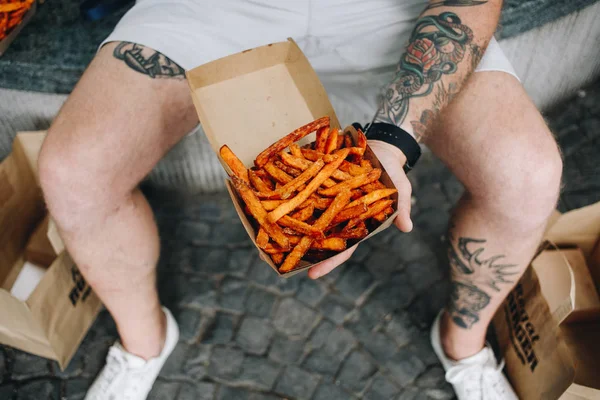 Hipster holds take away box of sweet potato fries — Stock Photo, Image