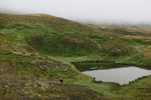 Modern photographer explorer in alpine lake — Stock Photo, Image