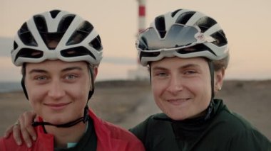 İki kadın bisikletçiler kamera ve gülümseme bakmak