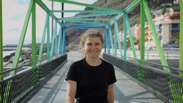 Jeune jolie femme marche sur le pont en métal arc-en-ciel — Video