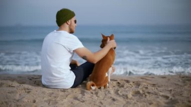 Plajda en iyi arkadaşı köpek ile genç milenyal adam