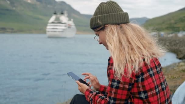 Mujer joven se sienta en puerto ver crucero salir — Vídeos de Stock