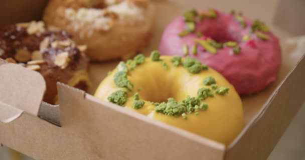 Deliciosos doces donuts coloridos em caixa takeaway — Vídeo de Stock