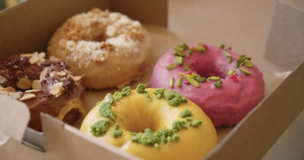 Deliciosos doces donuts coloridos em caixa takeaway — Vídeo de Stock