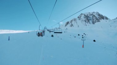 Güneşli kış gününde kayak koltuğu asansör sürme