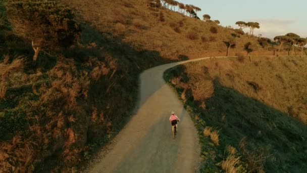 Bisikletle gün batımında kadın bisikletçidrone görüntüleri — Stok video