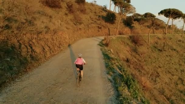 Bisikletle gün batımında kadın bisikletçidrone görüntüleri — Stok video