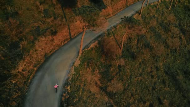 Drone footage of woman cyclist in sunset on bike — Stock Video