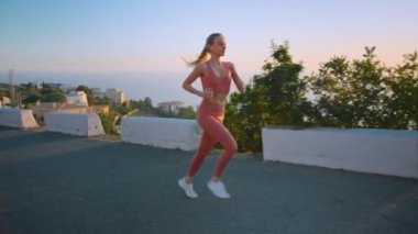 Şehirde gün doğumunda koşan güçlü atletik genç kadın.