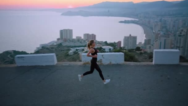 Kadın, eğitimden sonra kollarını kaldırıp destansı şehre doğru koşuyor. — Stok video