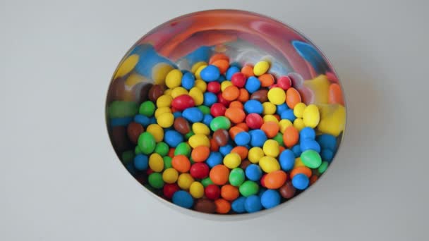 Mnoho barevných sladkých kuliček ve sklenici nebo misce — Stock video