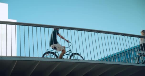 Велосипедисты на безопасной велосипедной дорожке в летнем городе — стоковое видео
