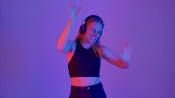 Frau hört Musik über Kopfhörer, fröhlicher Tanz — Stockvideo