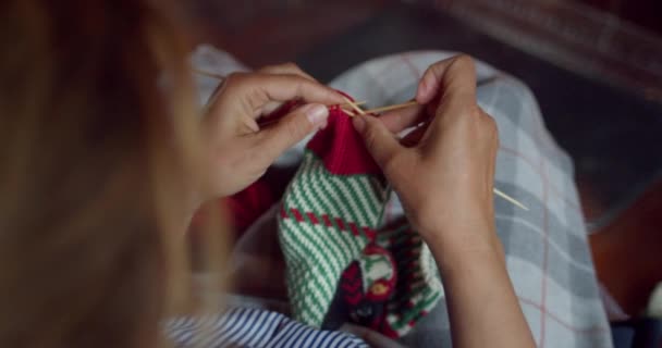 Vrouw breit rode wol wintersokken bij open haard — Stockvideo