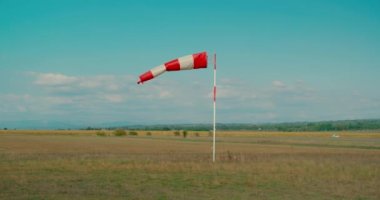 Windsock, sıcak bir yaz günü havaalanında rüzgârda savruluyor.