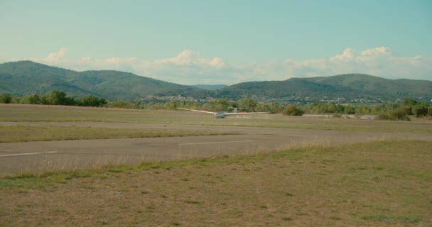 Klein zweefvliegtuig landt in landelijk vliegveld — Stockvideo
