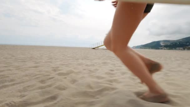 Joven hermosa mujer con tabla de surf en la playa — Vídeos de Stock