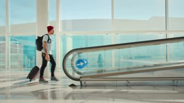 Büyük boş havaalanındaki modern gezgin kapıya gider.