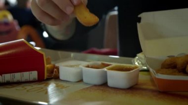 Fast food lokantasında arkadaşlar patates kızartması ve nugget paylaşır.