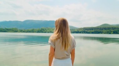 Genç bir kadının portresi doğal manzaranın tadını çıkarıyor.