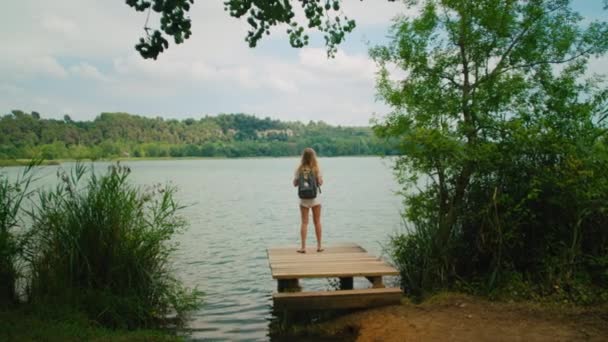 Ung kvinna njuta av lätt vandring till fjällsjö — Stockvideo