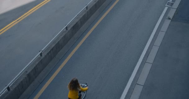 Mulher anda de bicicleta na ciclovia ao lado de estrada de carro grande — Vídeo de Stock